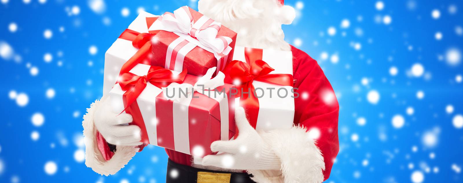 christmas, holidays and people concept - close up of santa claus with gift box over blue snowy background