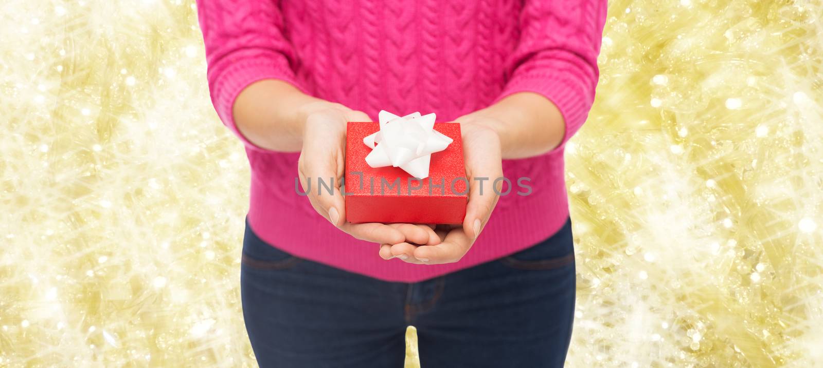 close up of woman in pink sweater holding gift box by dolgachov