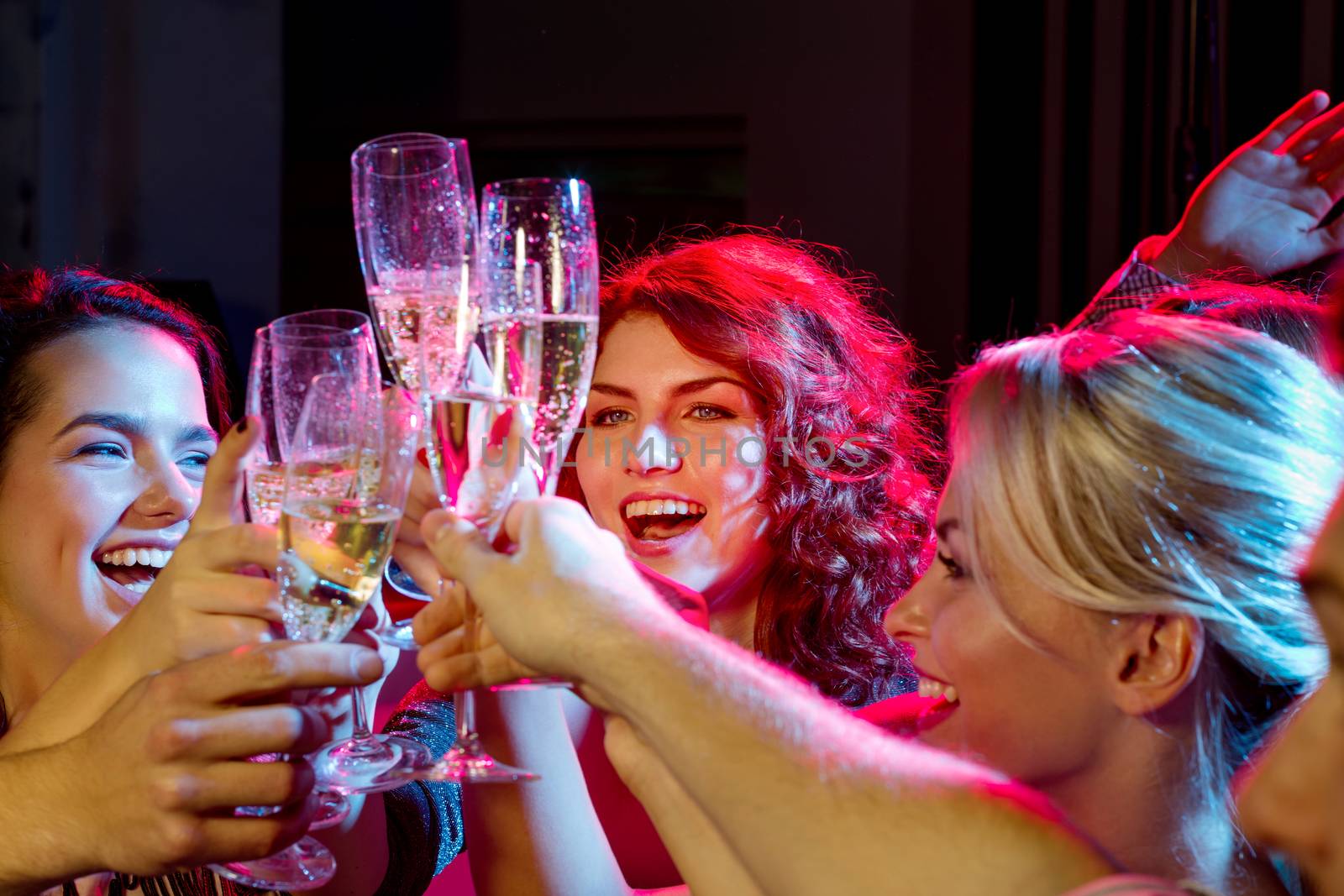 party, holidays, celebration, nightlife and people concept - smiling friends with glasses of champagne in club