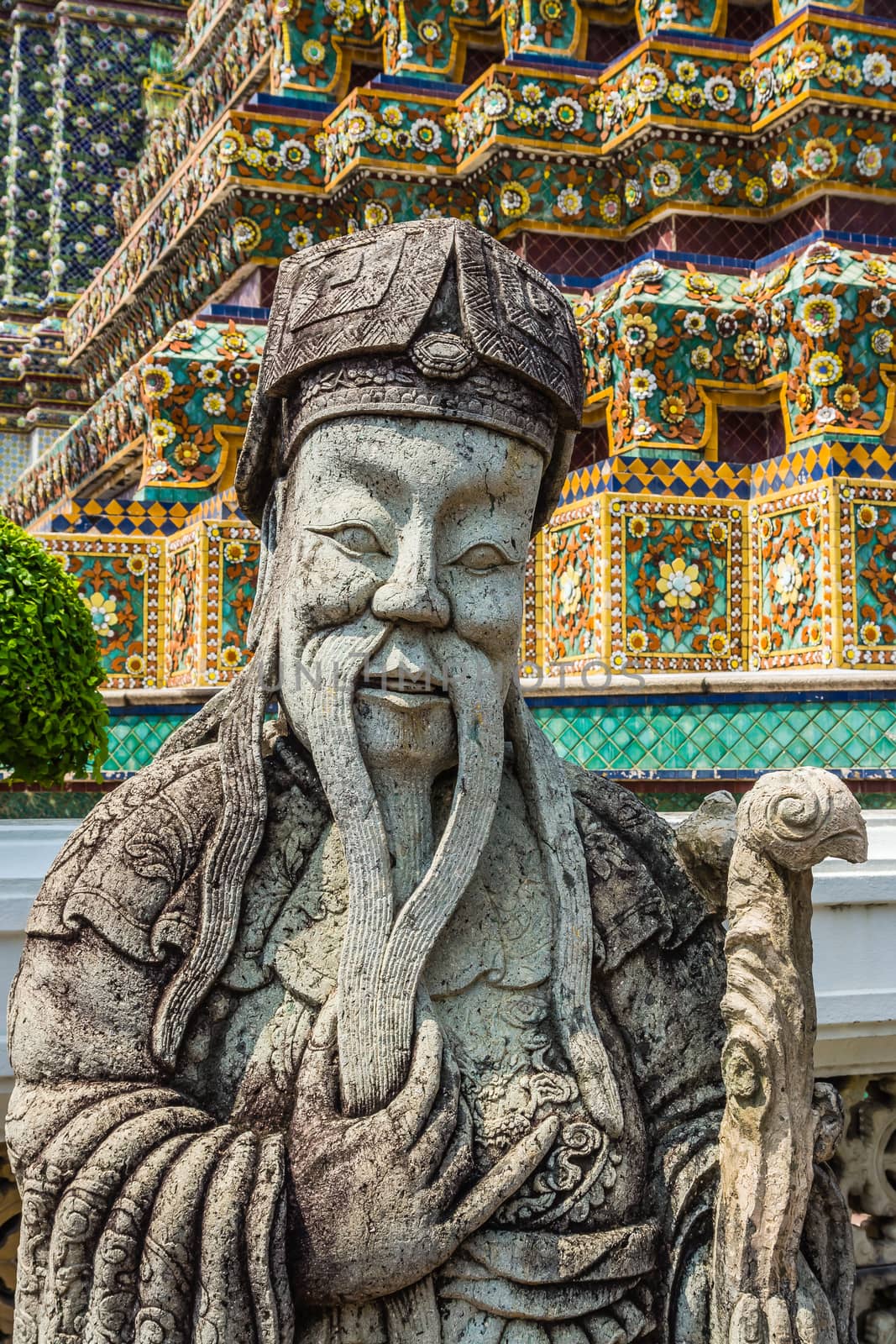 Ancient statue in the complex of Wat Pho, the Temple of the Reclining Buddha in Bangkok, Thailand.
