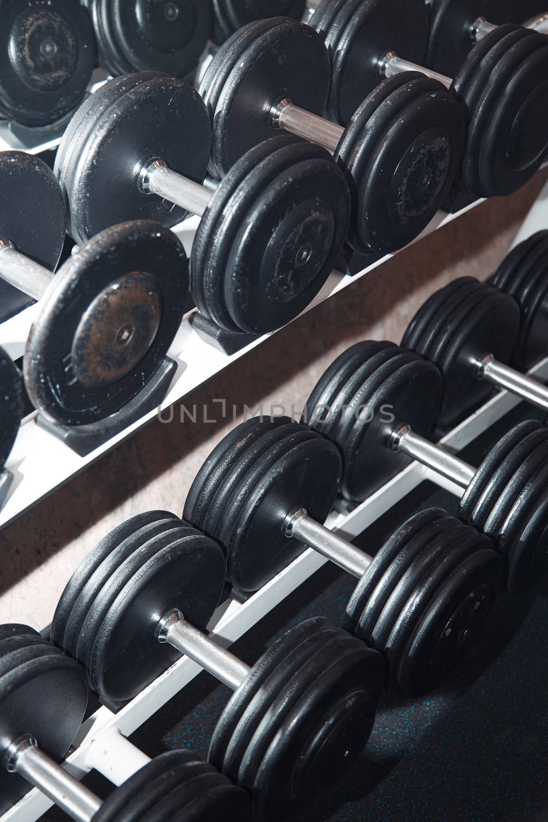 Group of barbells arranged in row at the gym. Vertical photo