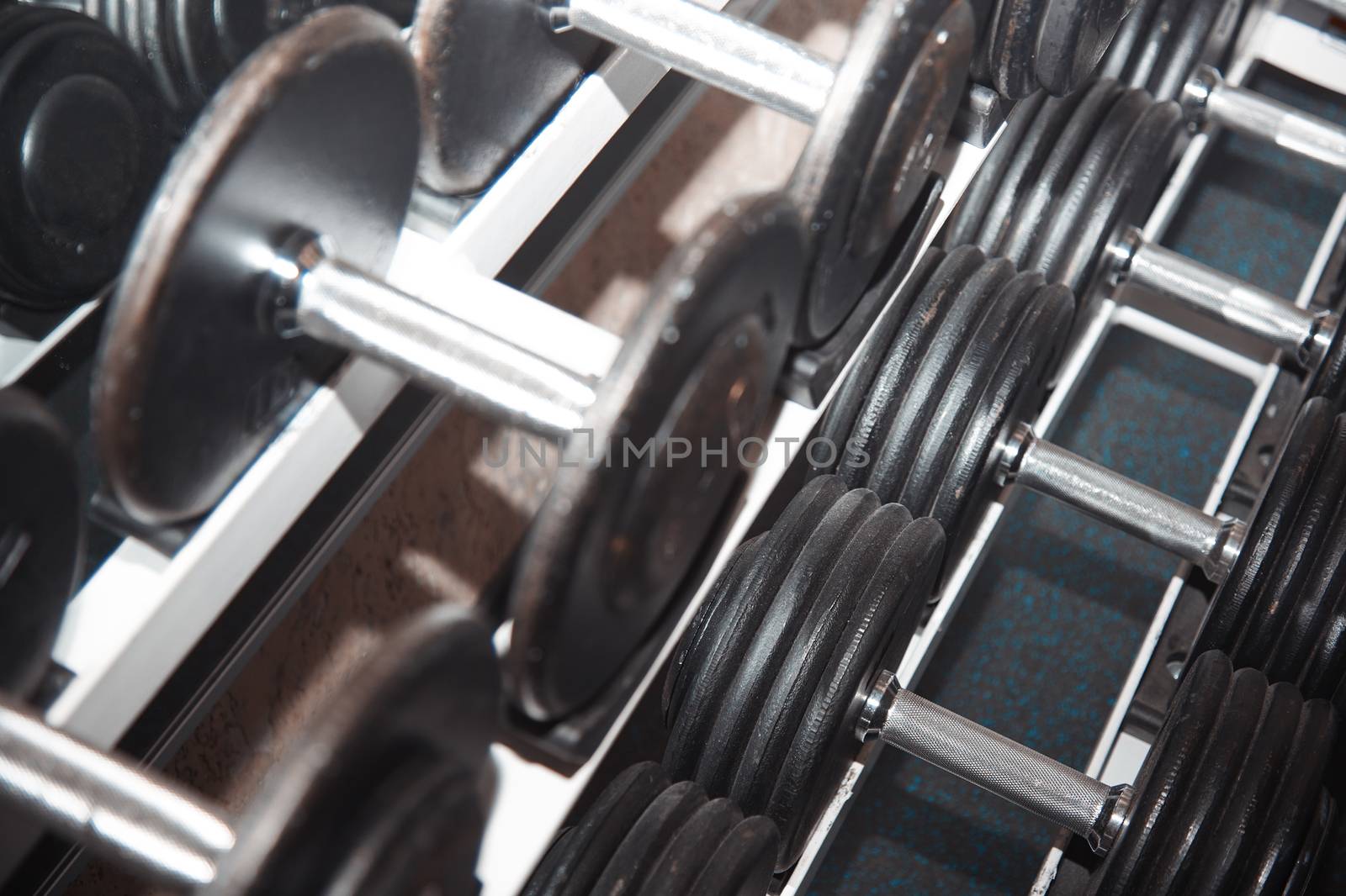 Group of barbells arranged in row at the gym. Horizontal photo