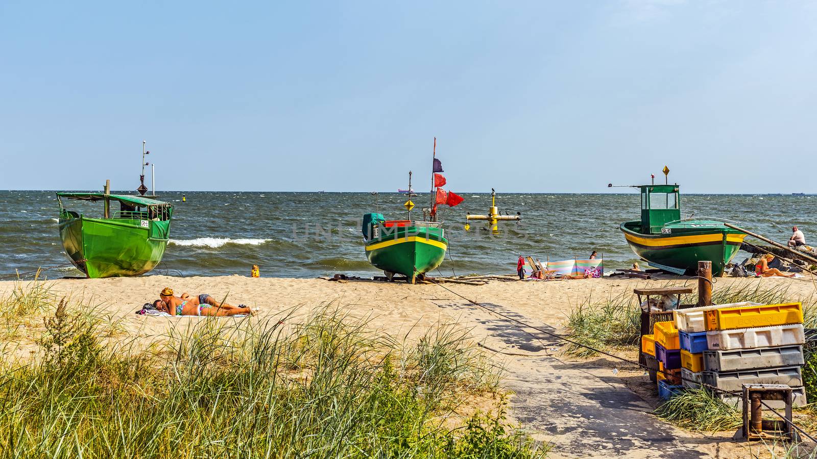People sunbath on a beach in Orlowo, district of Gdynia, former fishermen village founded in 1826. Main attractions are maritime cliffs and the pier at 180m long.