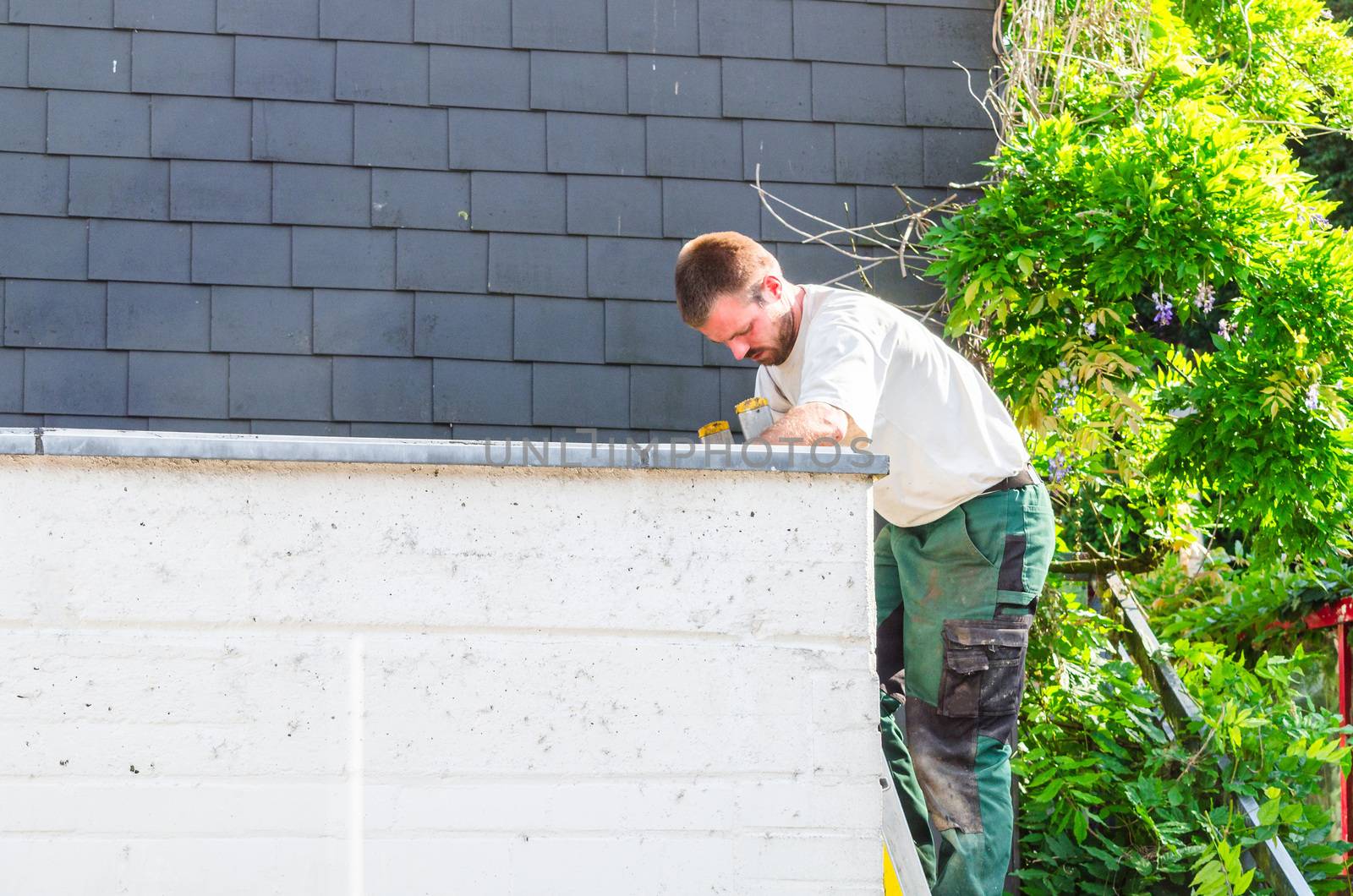 A construction worker in the repair on a garage roof.