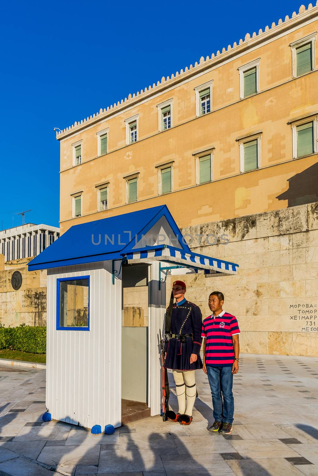 Tourist poses to the photo with the guard at the Tomb of the Unknown Soldier. The guard is held by The Evezones, a ceremonial unit of The Presidential Guard.