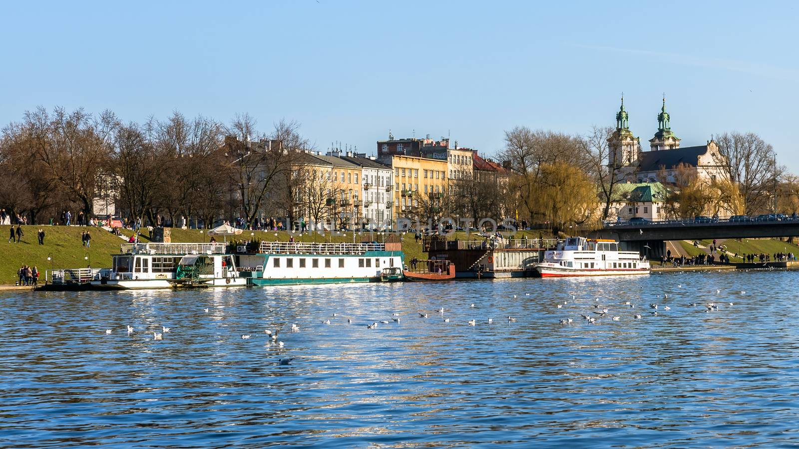 Pleasure boats moored at the harbor on Vistula river in Krakow, historical seat of Polish kings, the most popular destination in Poland.