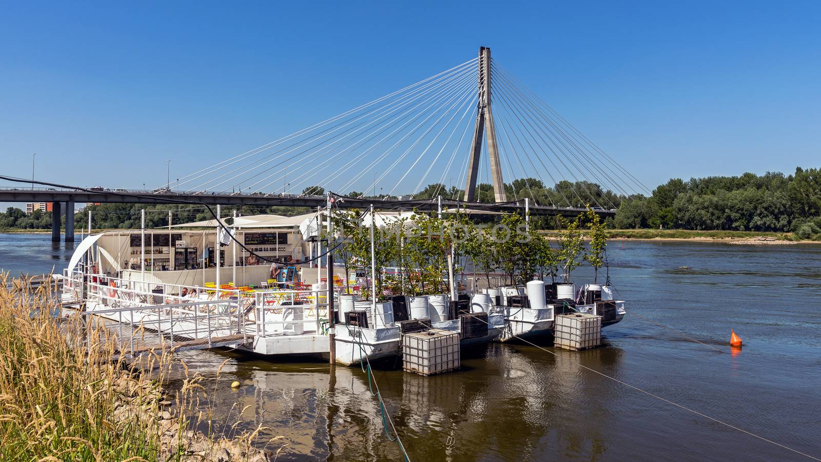 The Swietokrzyski Bridge over Vistula river in Warsaw preceded by the floating restaurant, first modern cable-stayed bridge in Warsaw, 479 m long with the tower 90 m high.