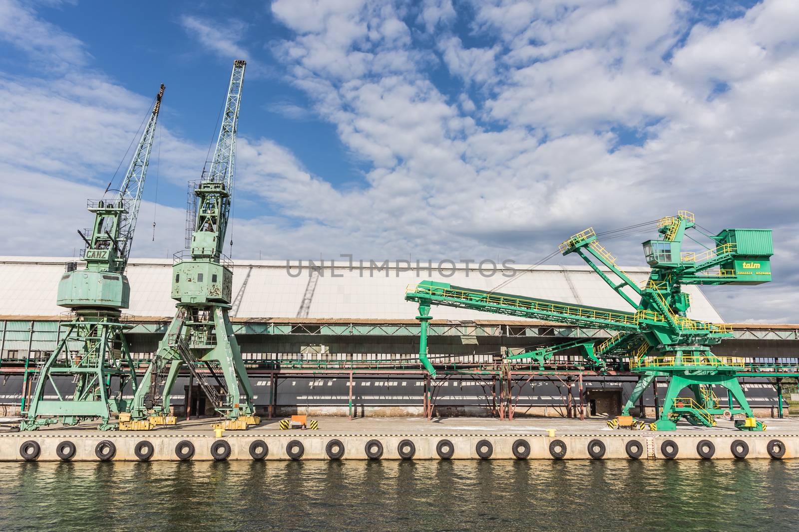 Cranes on the quay in the Port of Gdansk, the largest seaport in Poland, a major transportation hub in the central part of the southern Baltic Sea coast.