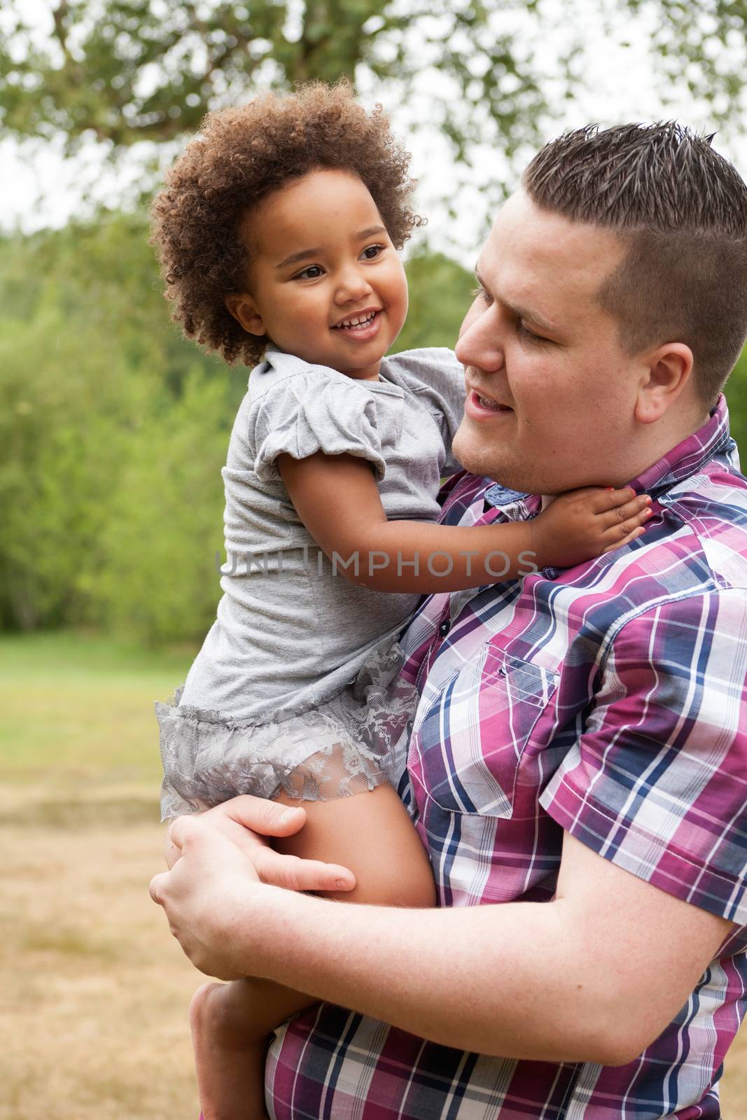 Blank father with his african daugther having a nice time