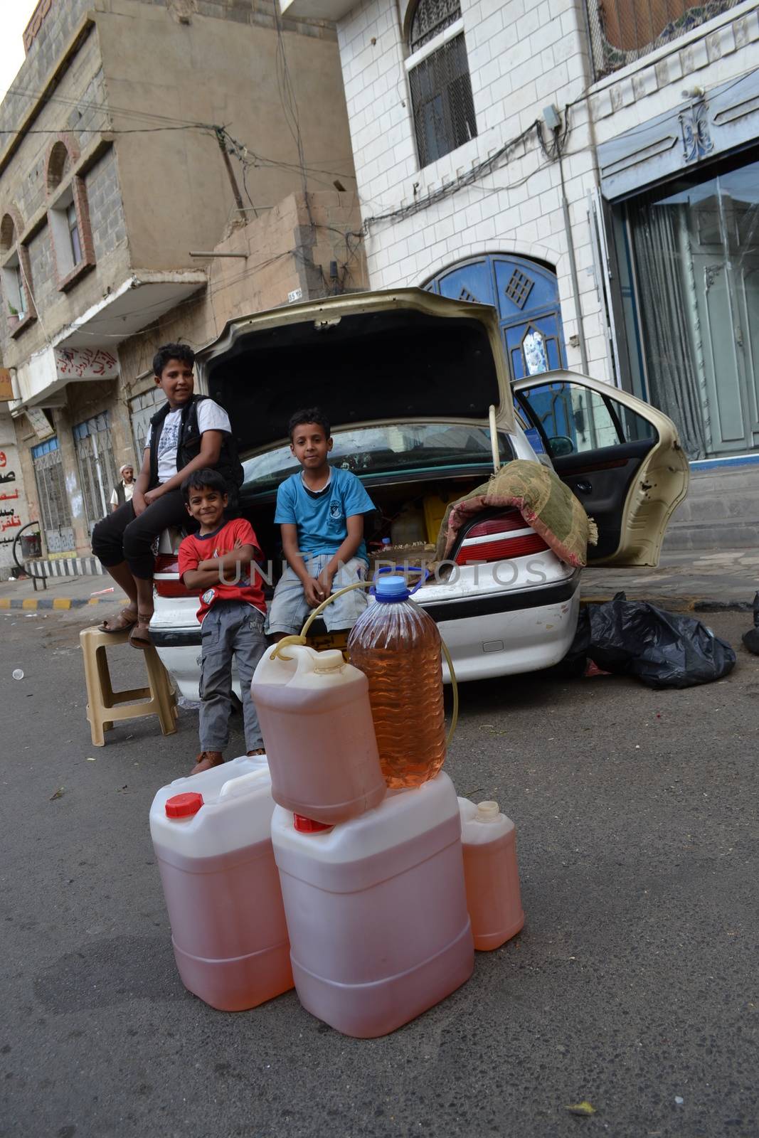 YEMEN, Sanaa: Children pose with black market bottles of petrol in Sanaa, Yemen's capital, on November 7, 2015, as petrol stations have closed since the beginning of the war and Saudi bombings over the country.