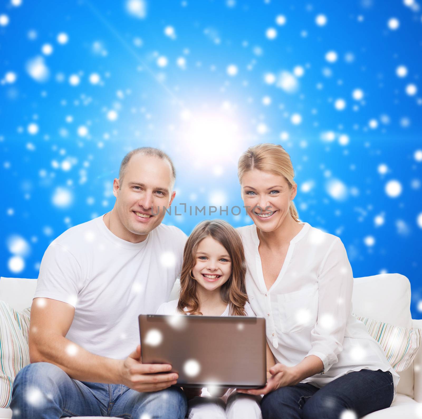 family, christmas, holidays, technology and people concept - smiling family with laptop computer over blue snowy background