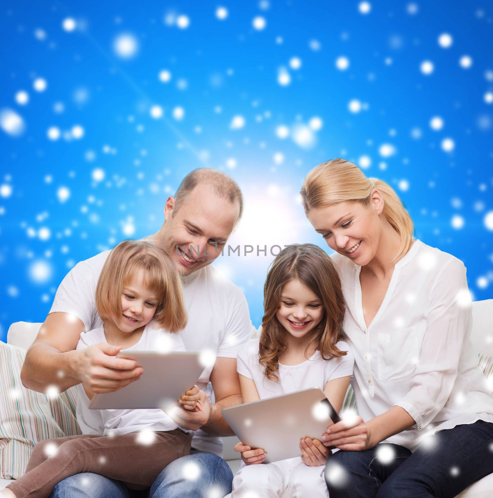 family, holidays, christmas technology and people - smiling mother, father and little girls with tablet pc computers over blue snowy background