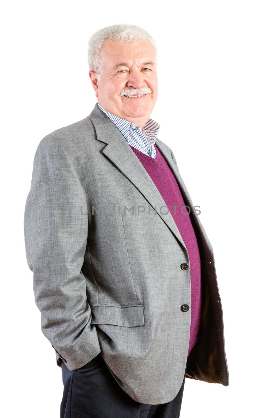 Three Quarter Shot of a Confident Senior Businessman with Hand inside the Pocket, Smiling at Camera Against White Background.