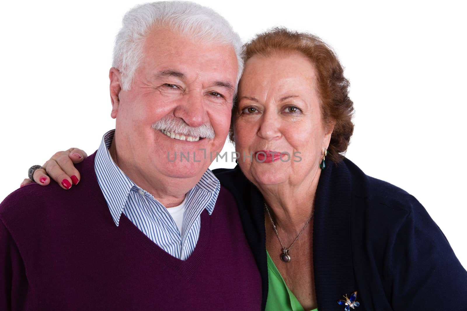 Happy loving senior couple posing in a close embrace smiling happily at the camera, head and shoulders portrait isolated on white