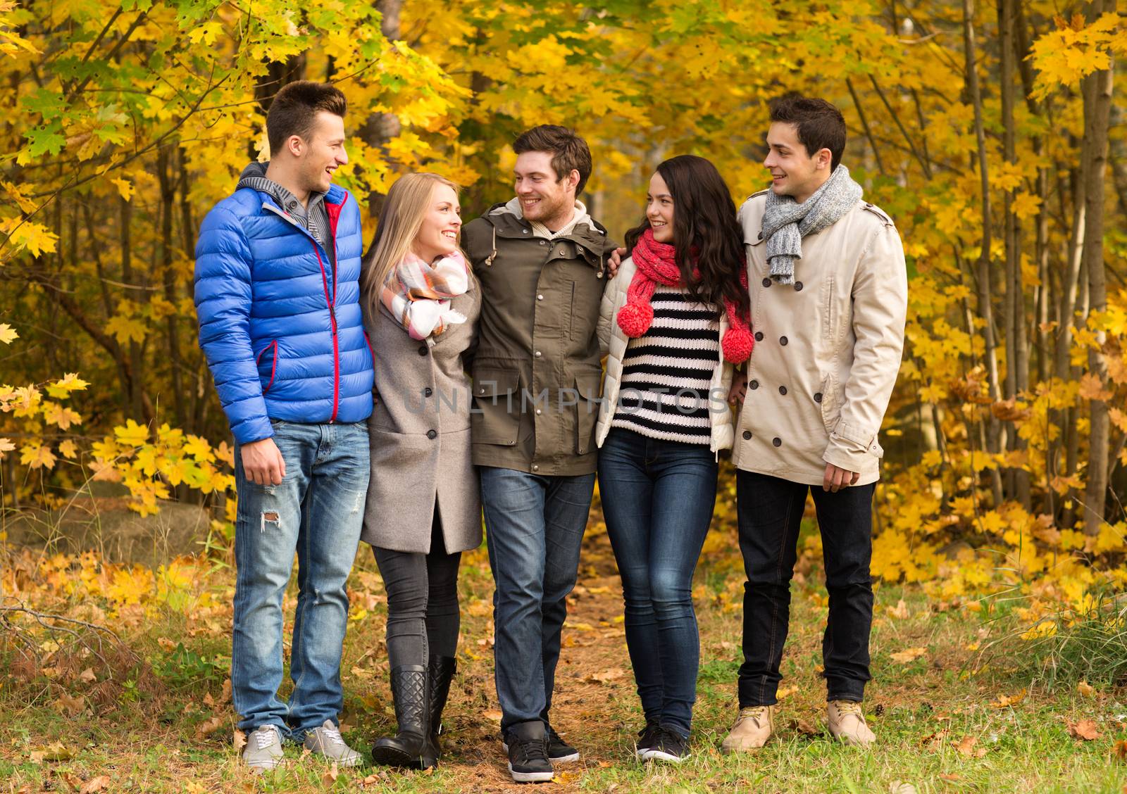 group of smiling men and women in autumn park by dolgachov