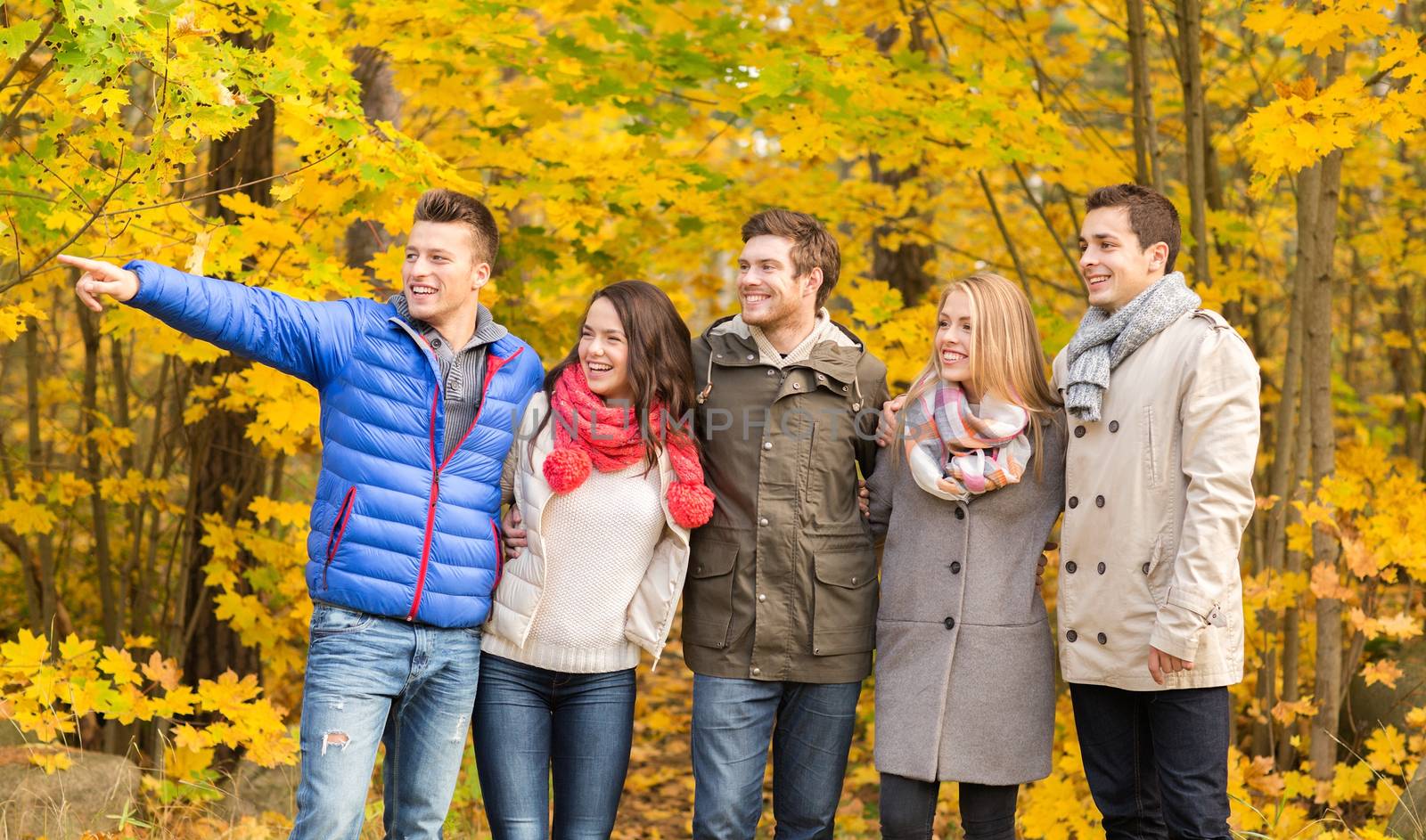 group of smiling men and women in autumn park by dolgachov