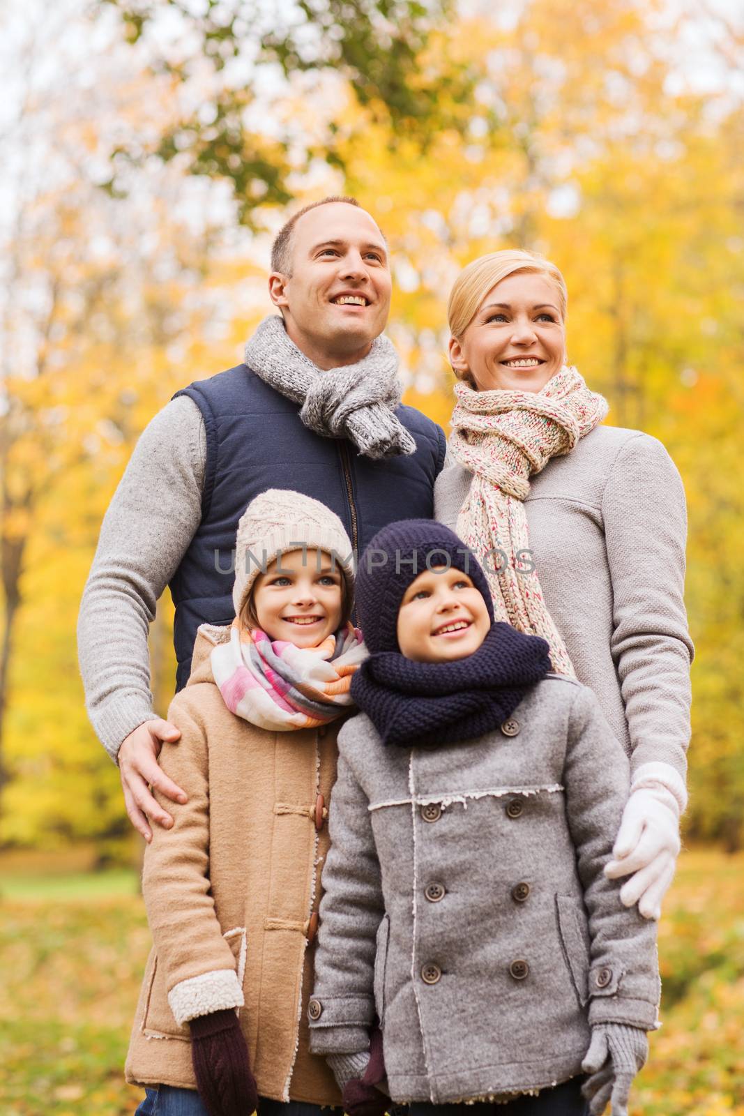 family, childhood, season and people concept - happy family in autumn park