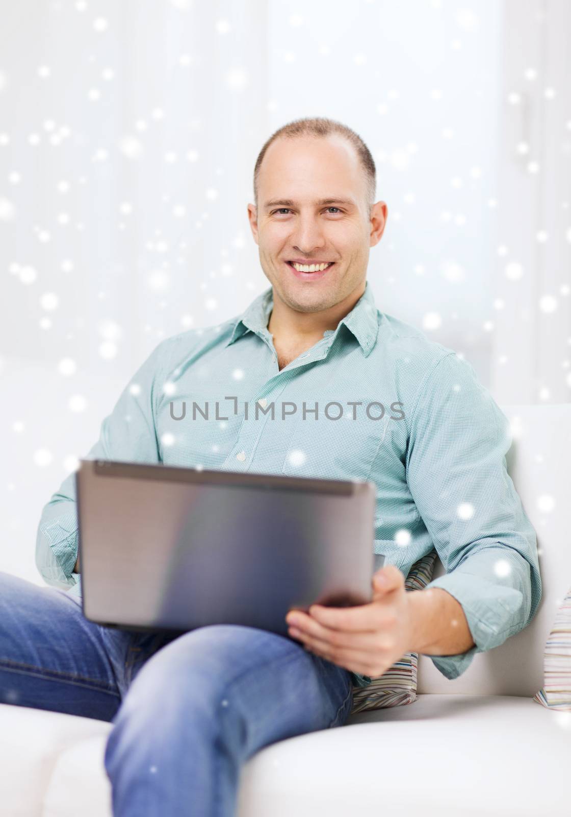 technology, business and lifestyle concept - smiling man working with laptop at home