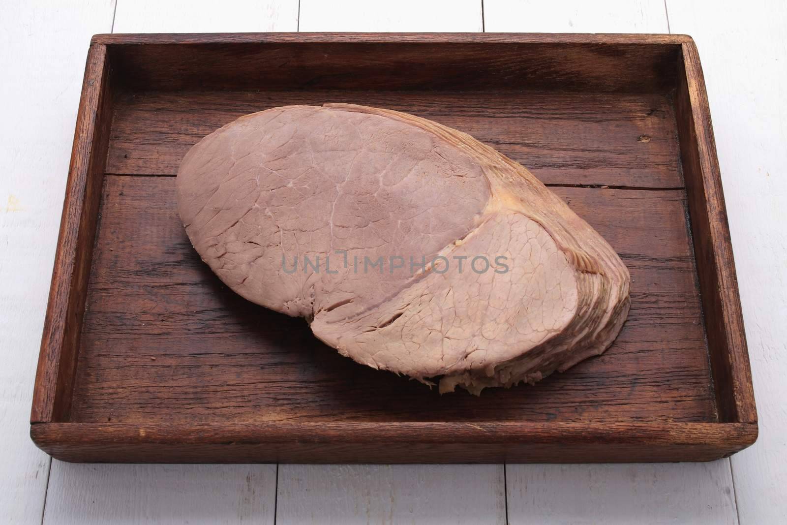 sliced roast beef on wooden platter
