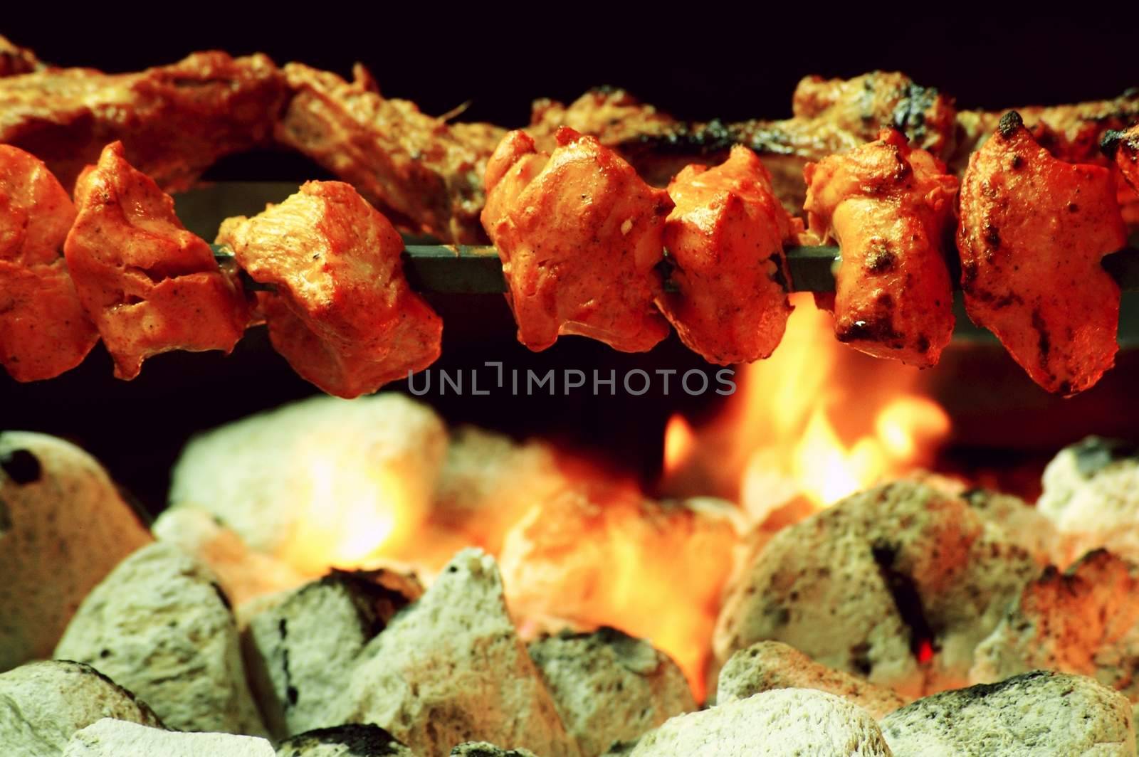 Indian kebabs cooking over coal barbecue