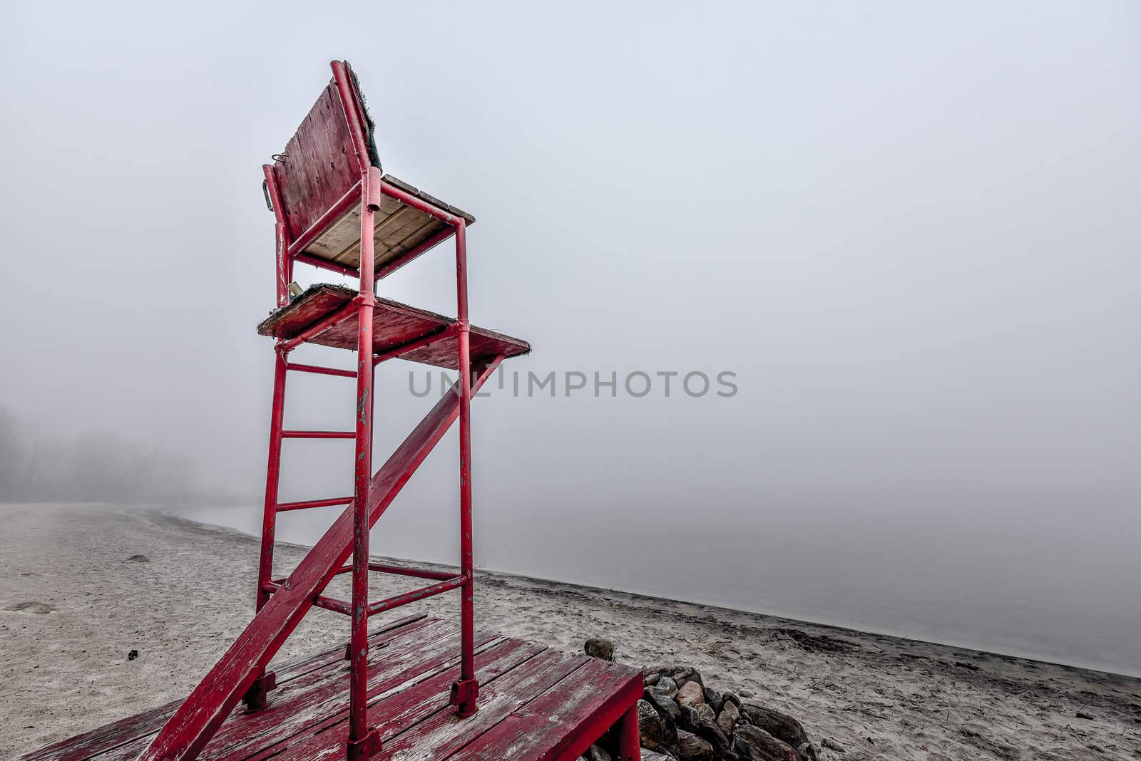 Empty lifeguard chair on morning foggy beach. by valleyboi63