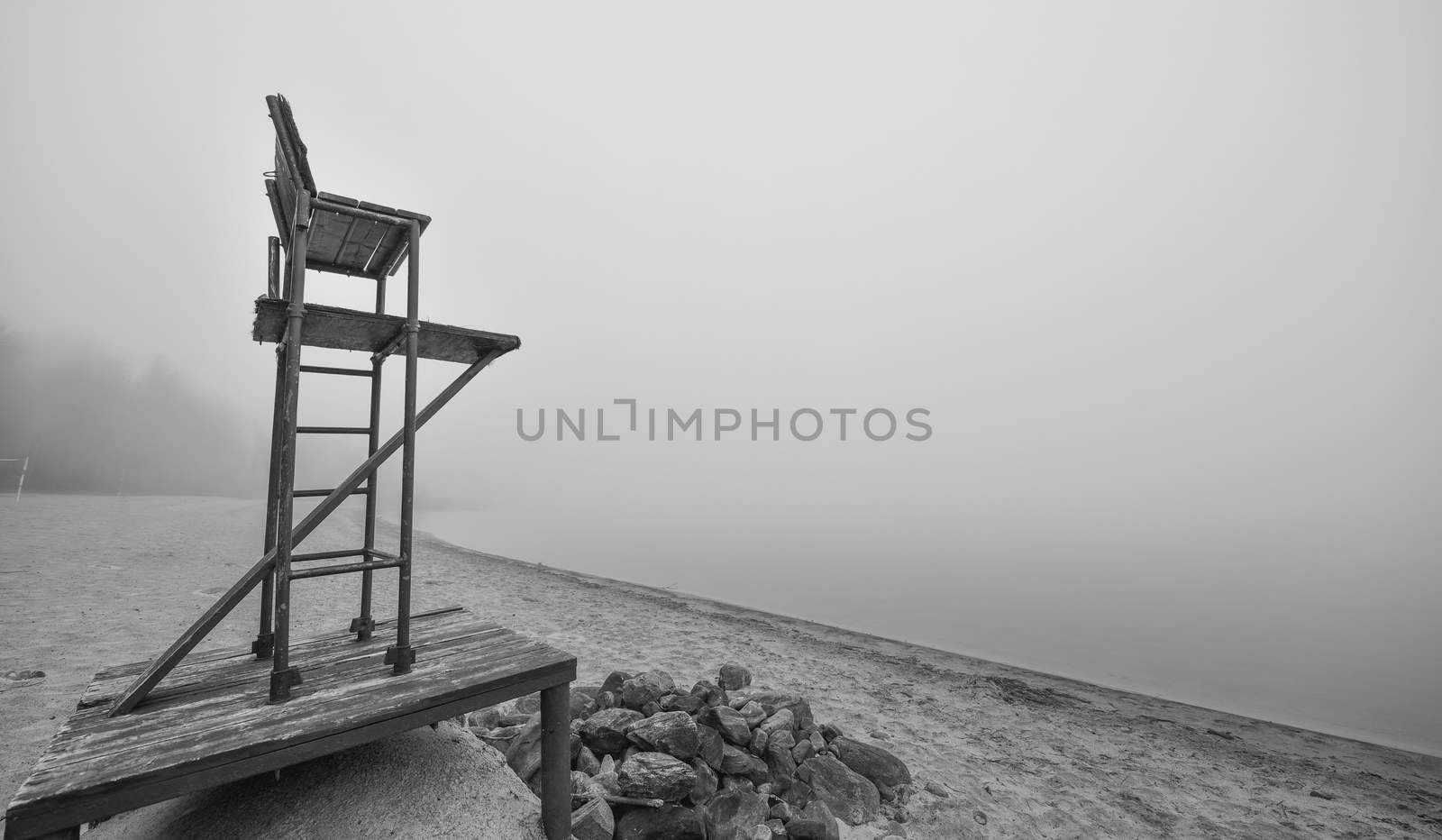 Empty lifeguard chair on morning foggy beach. by valleyboi63