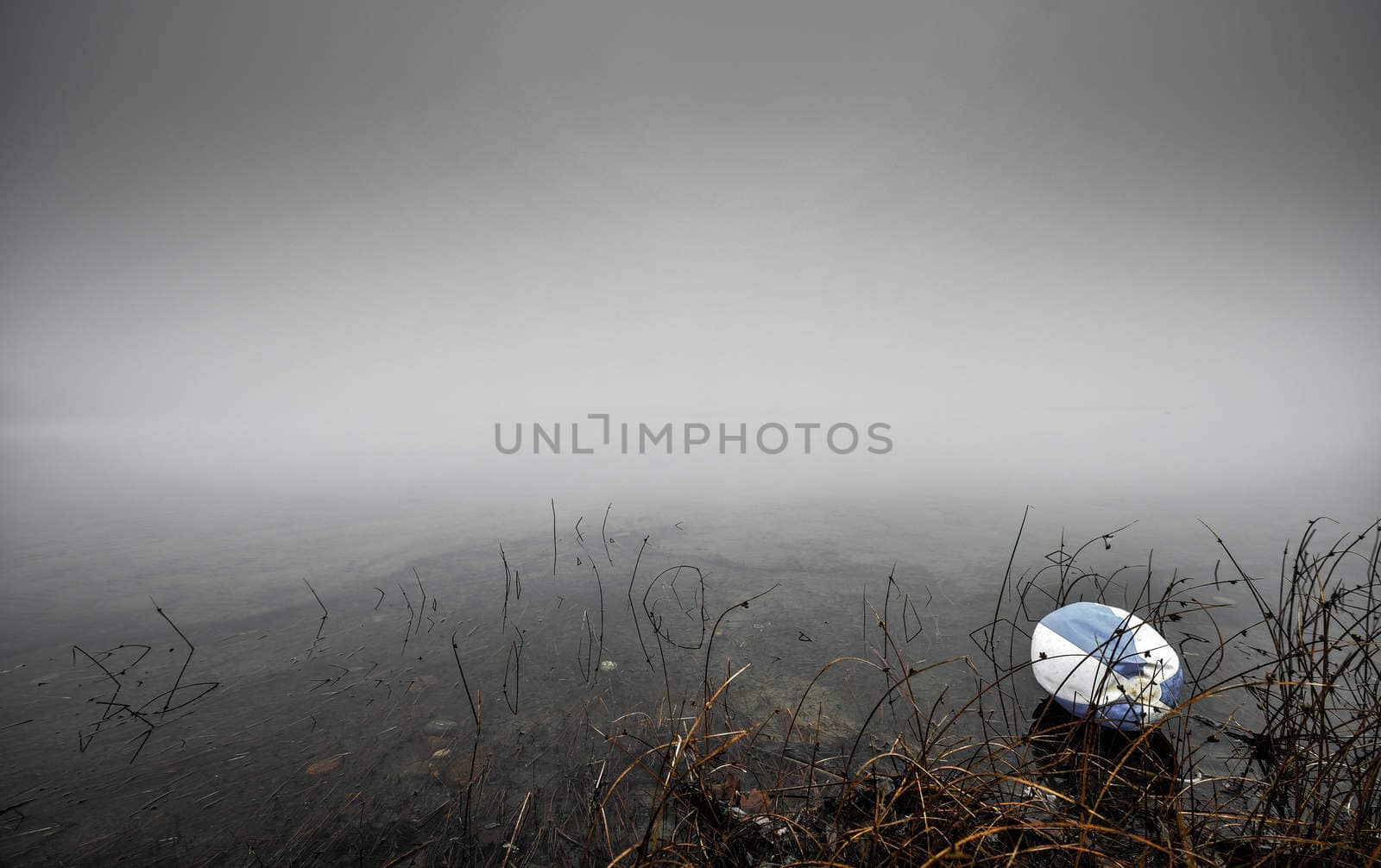 A cold November morning for a forgotten old beach ball on the shoreline of a lake in Ontario Canada.