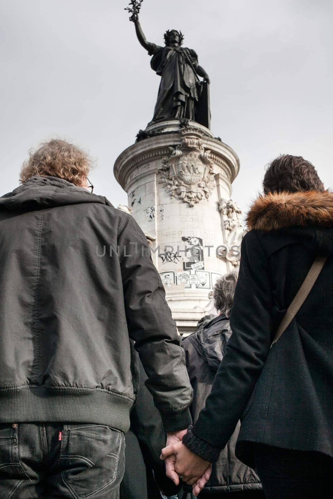 FRANCE, Paris: A man and woman hold hands as a moment of silence is held at Place de la Republique in Paris, France on November 16, 2015. Mourners gathered at Place de la Republique and the Eiffel Tower to pay tribute to the 129 people killed in Friday's terrorist attacks. A moment of silence was held in Paris at noon local time, with many across the world joining in.