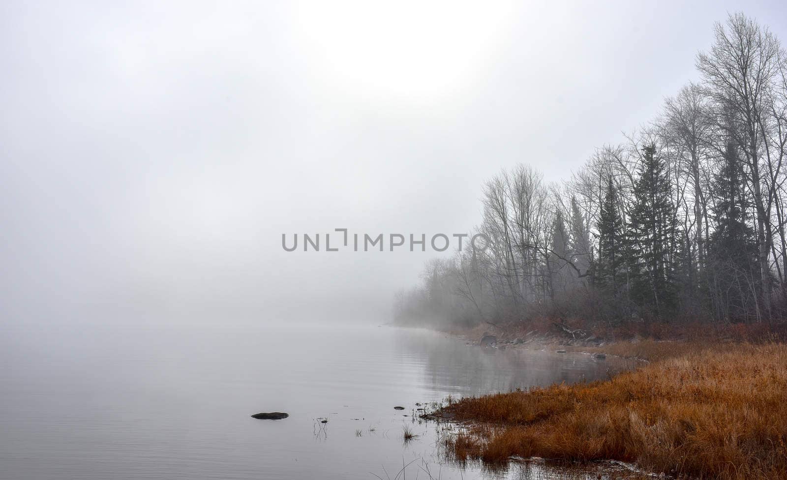 Rapidly changing thick fog envelopes the bay - obscured sunshine beaming through, bright diffusion, early sunrise Pembroke, Ontario.