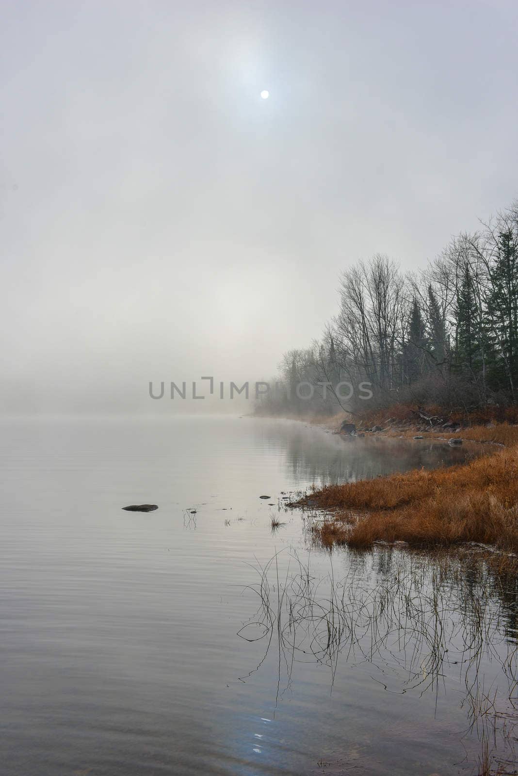 Rapidly changing thick fog envelopes the bay - obscured sunshine beaming through, bright diffusion, early sunrise Pembroke, Ontario.