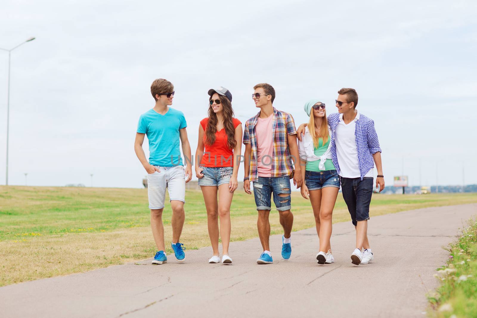 group of smiling teenagers walking outdoors by dolgachov