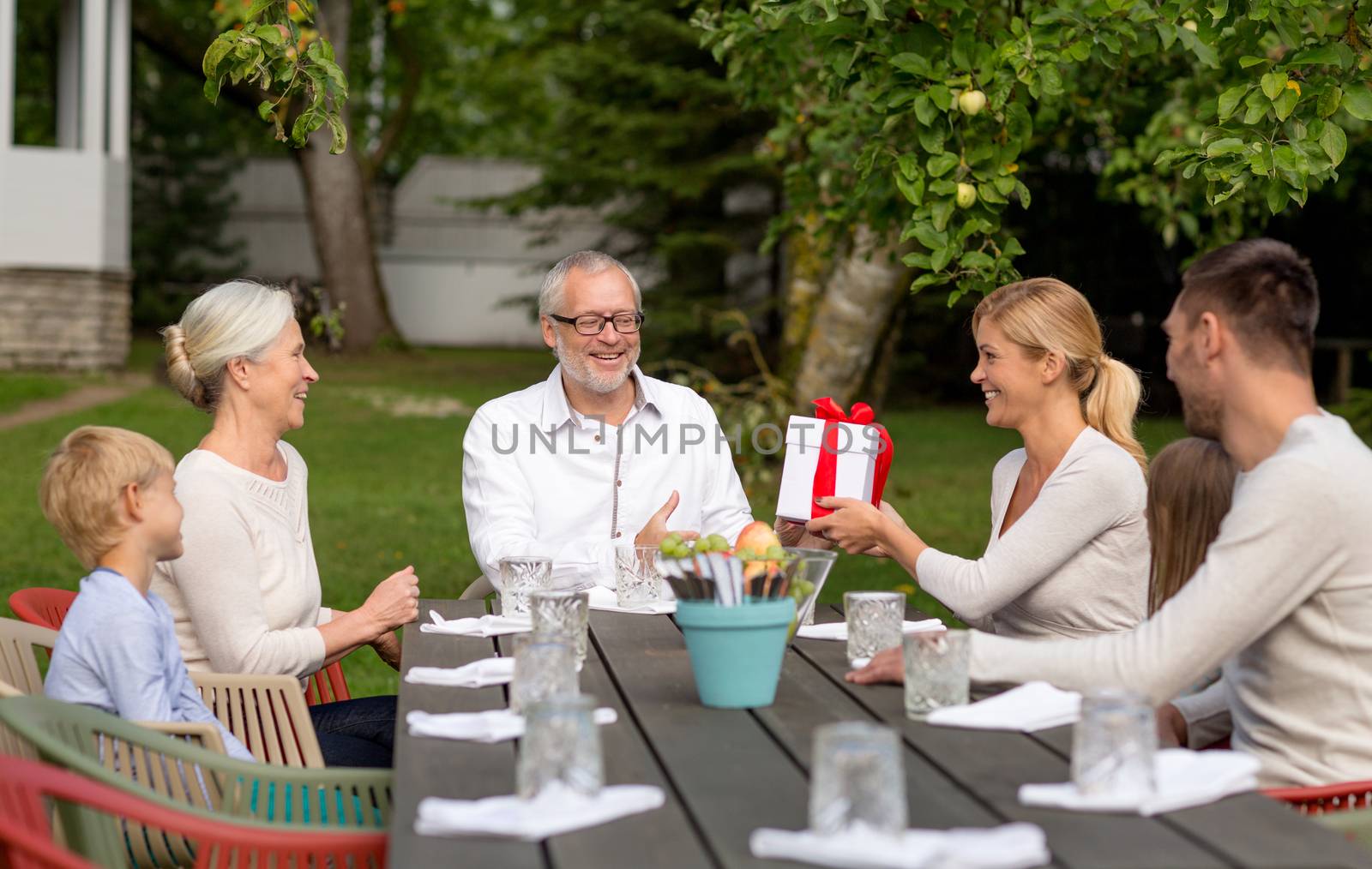 happy family having holiday dinner outdoors by dolgachov