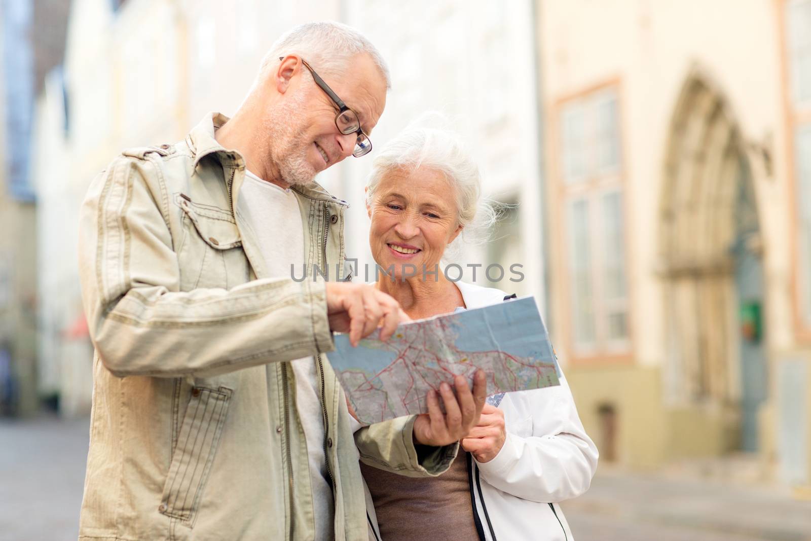 family, age, tourism, travel and people concept - senior couple with map and city guide on street