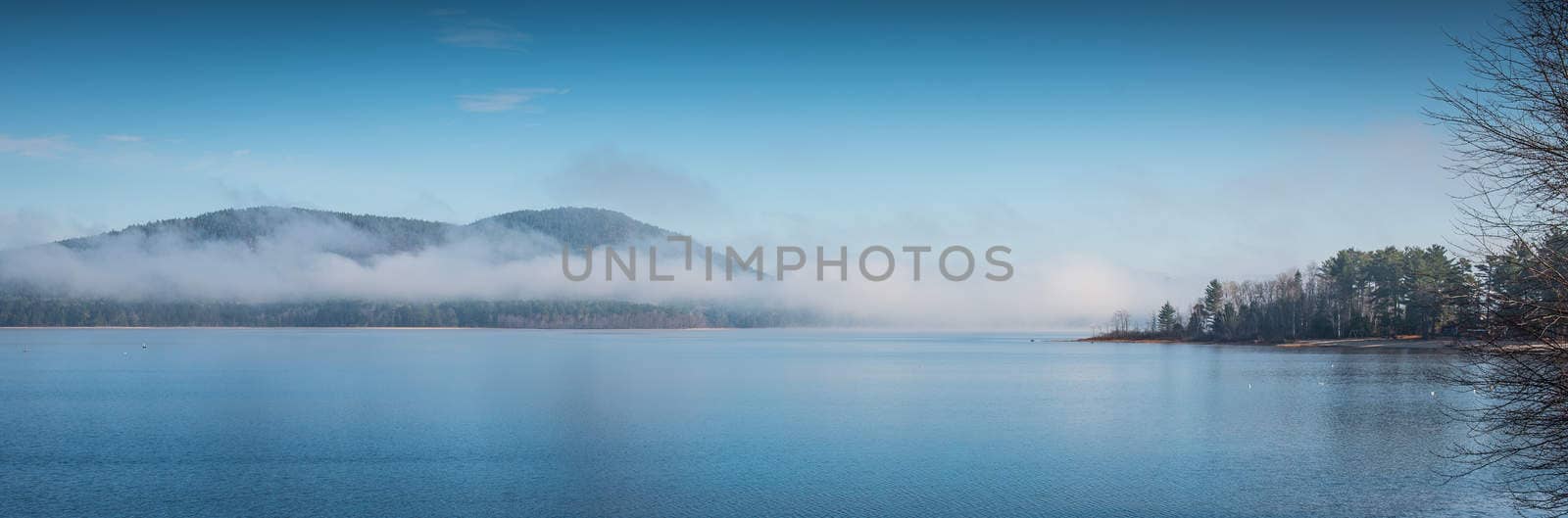 Fog rising from blue water into sky  - Panoramic fog lifting off the Ottawa River in late morning with Laurentian Hills and mountains -