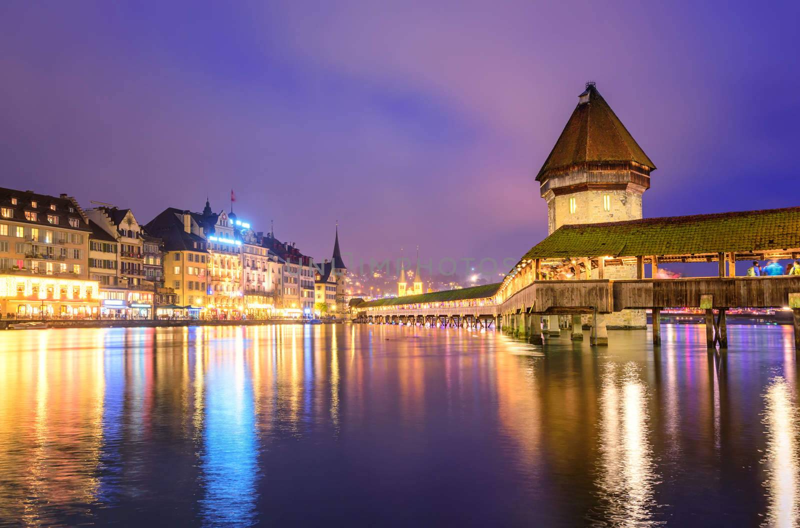 Lucerne, Switzerland, night view over the Reuss river to the wooden Chapel bridge and Water tower