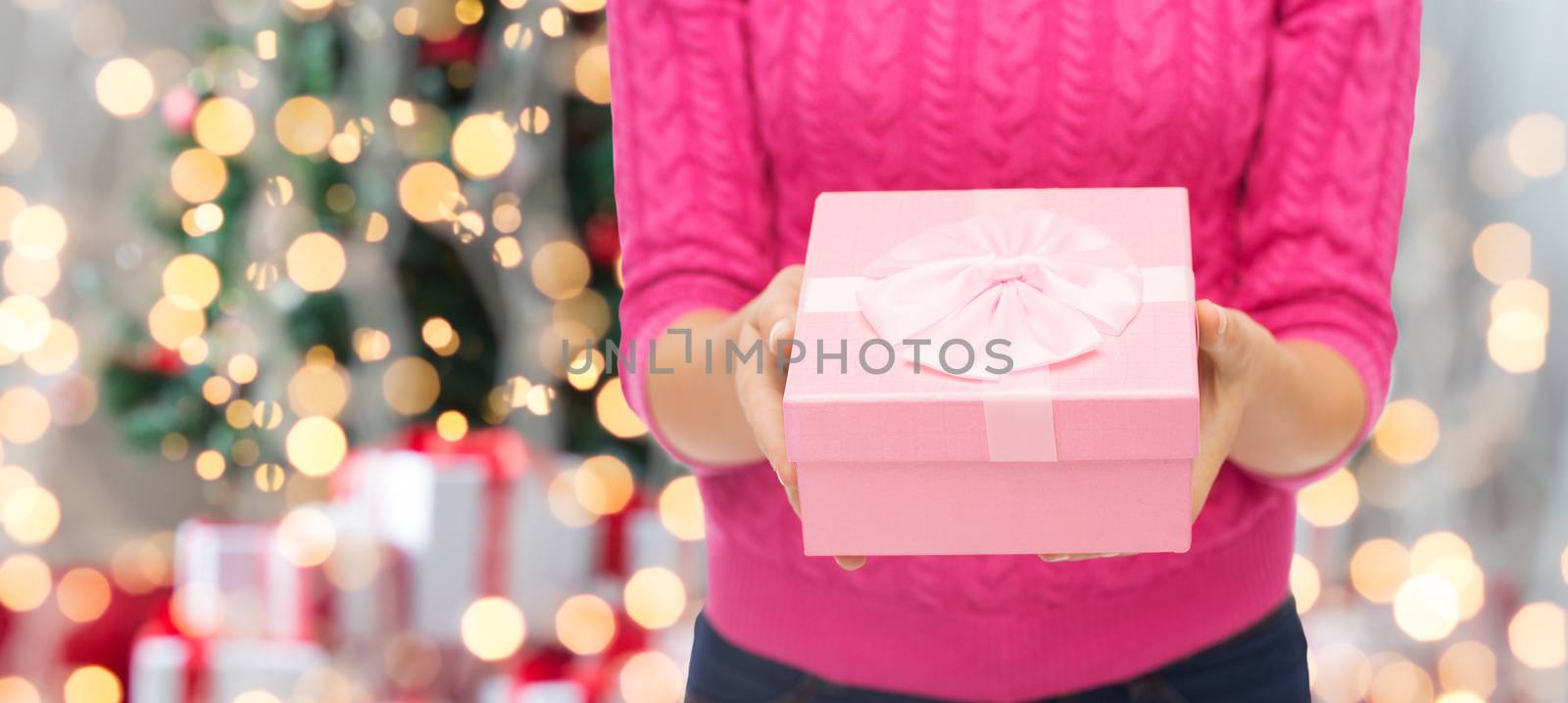 close up of woman in pink sweater holding gift box by dolgachov