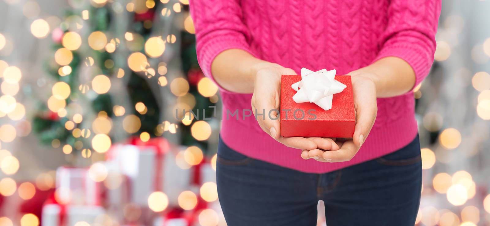 close up of woman in pink sweater holding gift box by dolgachov