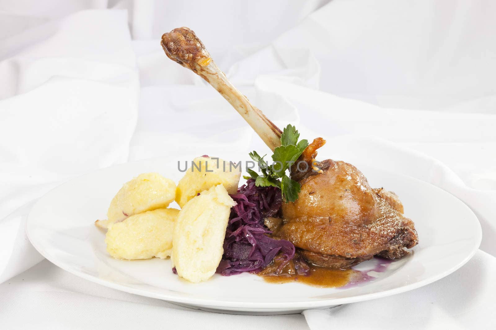 Baked duck leg with potato dumplings and red cabbage