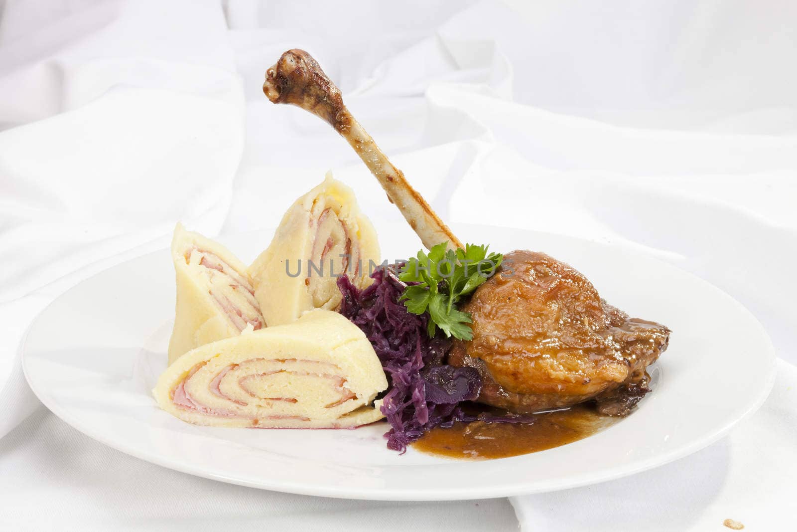 Baked duck leg with potato ham rolls and red cabbage