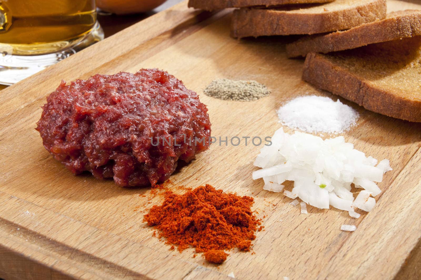 Steak tartar with the fried bread on the wooden trencher