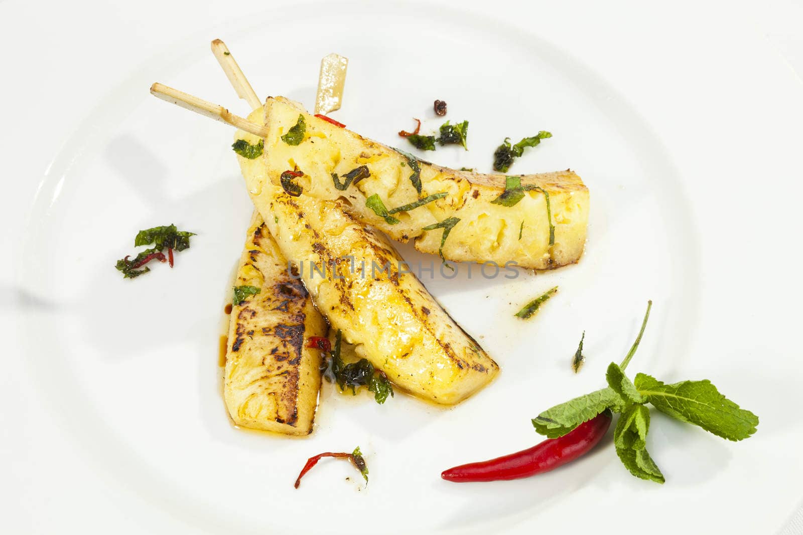 Grilled ananas with honey and mint leaves