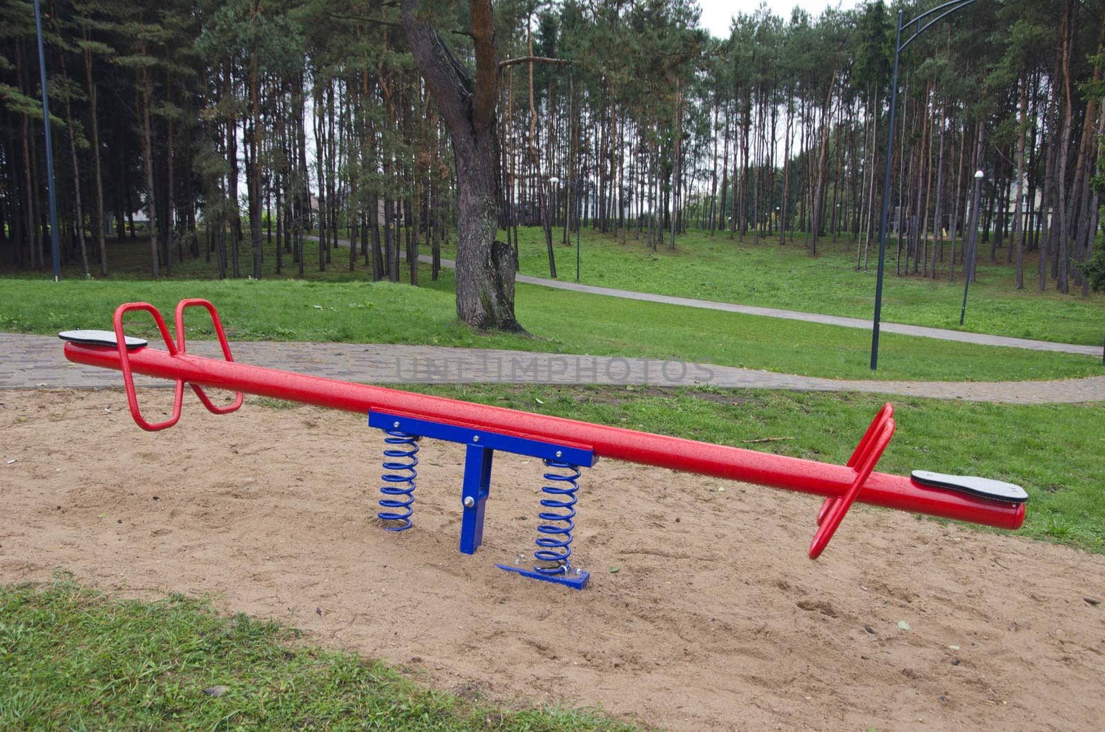 Red and blue metal children seesaw in the park   