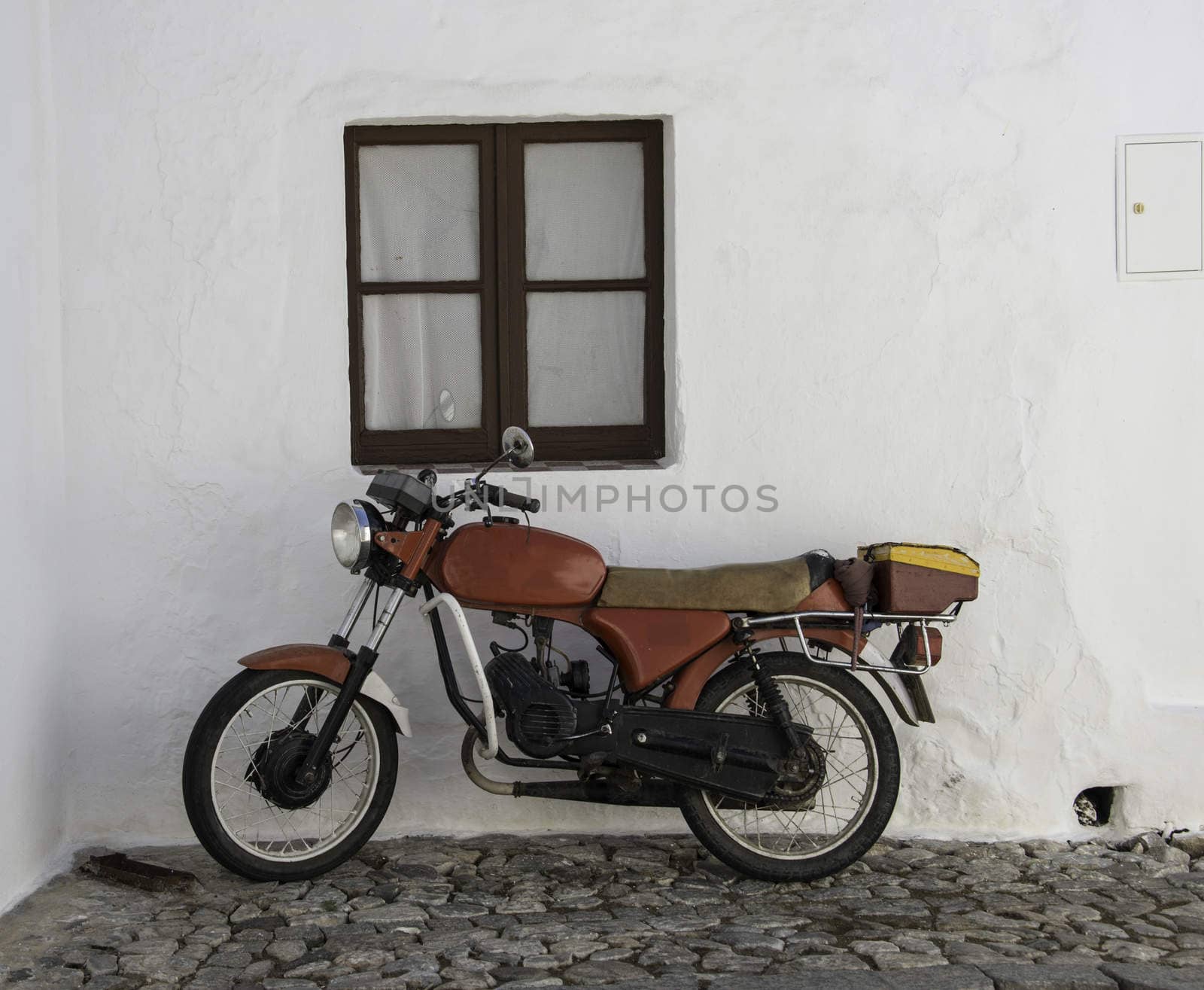 old red motor in street with white house