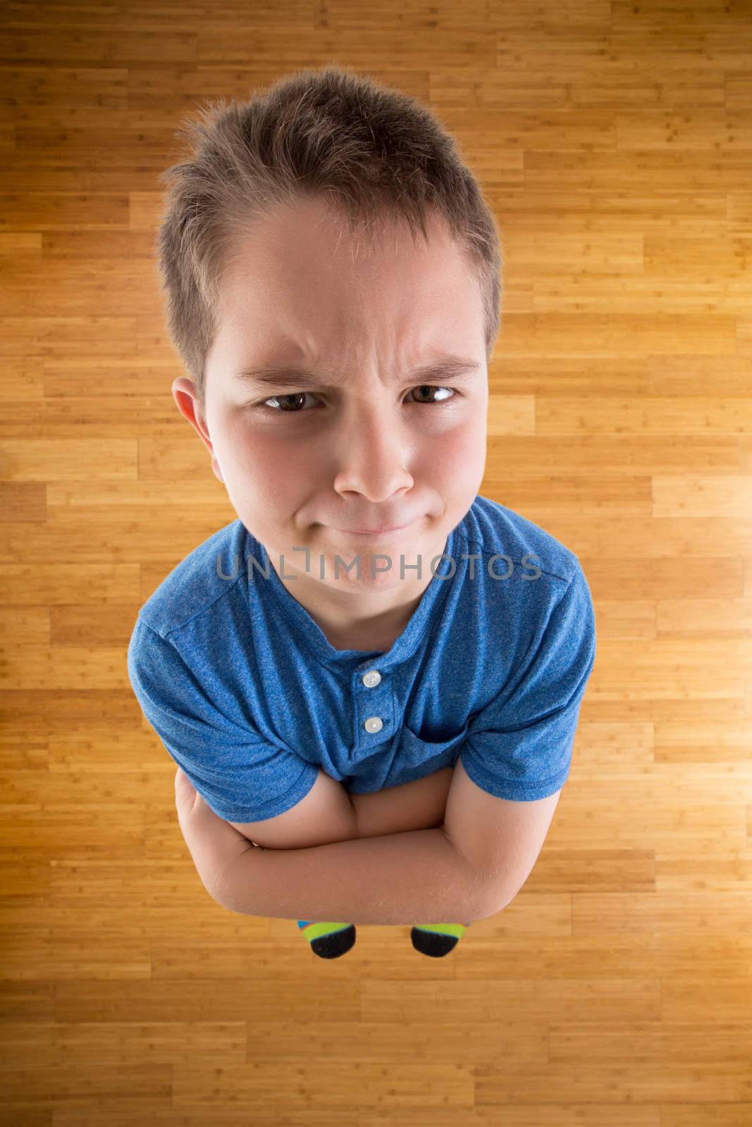 Cute Young Boy Demanding What he Wants While Looking at the Camera from High Angle View with Arms Crossing Over his Chest.
