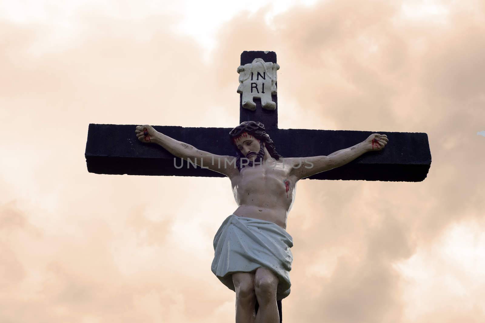 large crucifix in a graveyard in county tipperary ireland against a cloudy sky