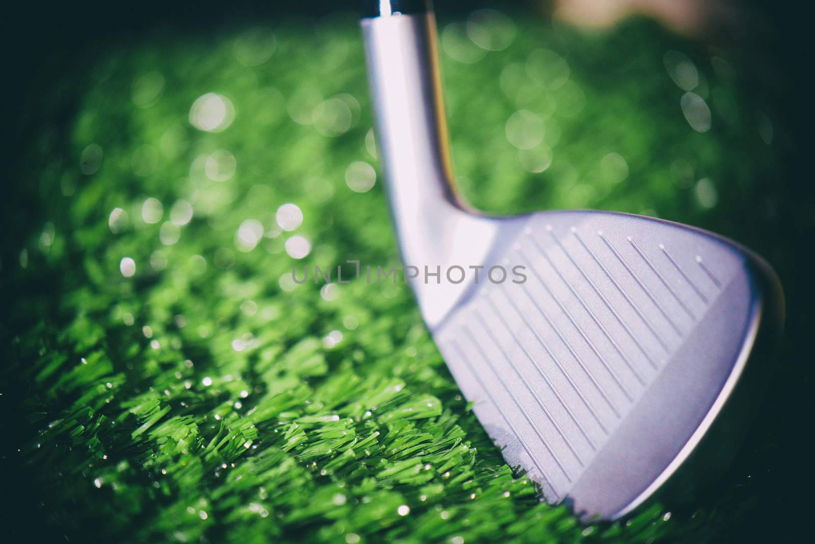 Golf club head open face iron detail against turf