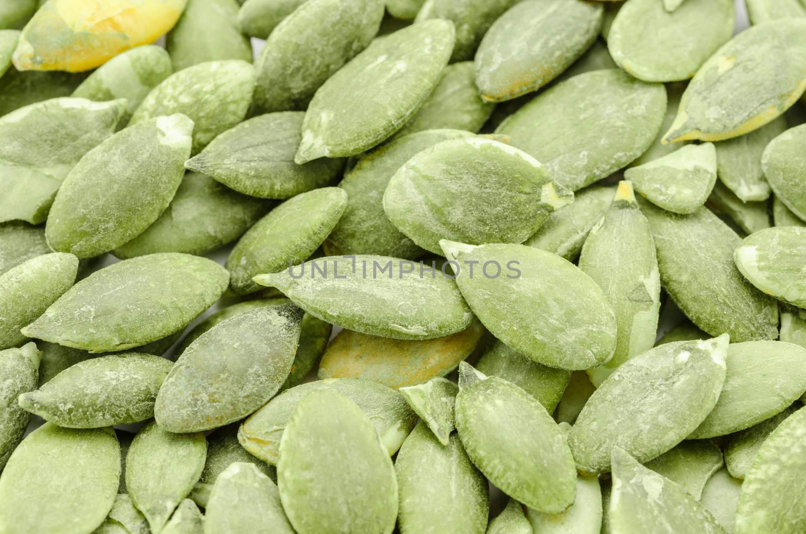Macro background texture of green pumpkin seeds.