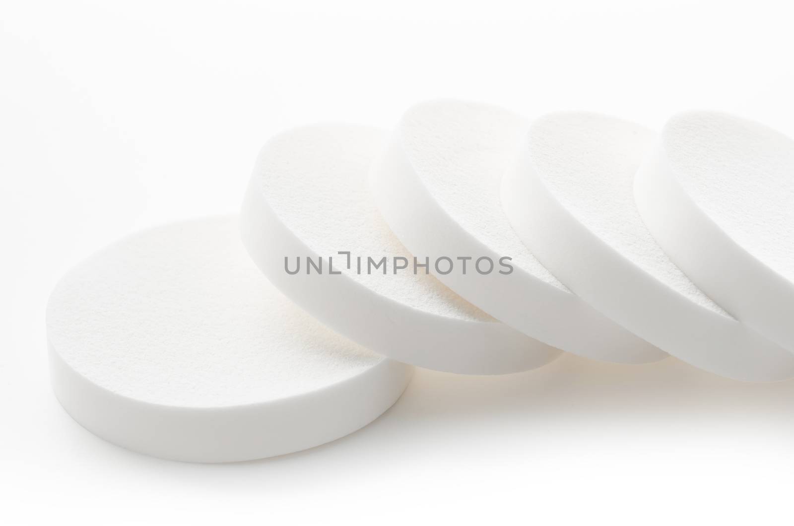 White cosmetic circle sponges for makeup on white background