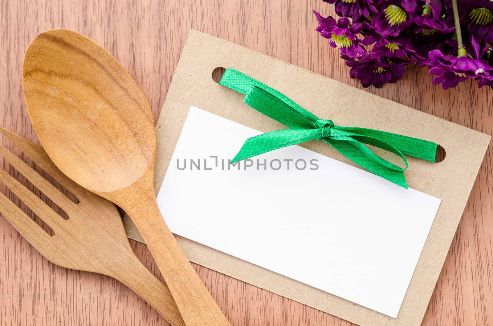 Blank paper tag and wooden spoon with flower. by Gamjai