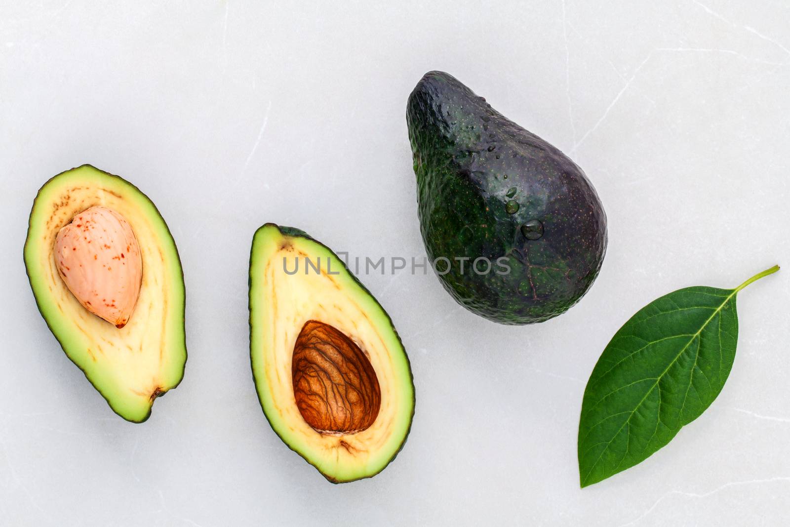 Alternative health care fresh  avocado and leaves on marble back by kerdkanno